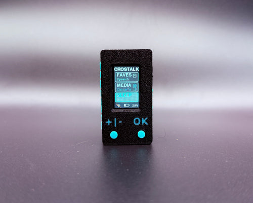 CROSTALK front view: black textured case, color screen showing the Faves, Media and Sleep menu, and two teal buttons