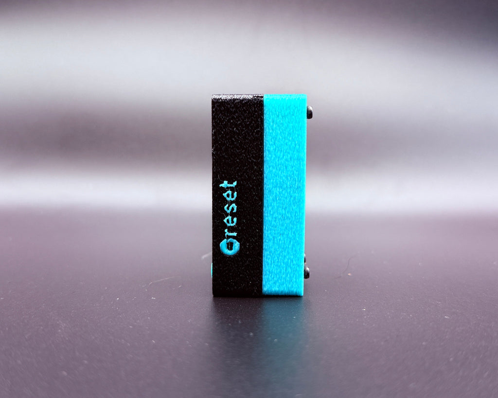 CROSTALK side view showing the recessed reset button, labeled in teal on the black case