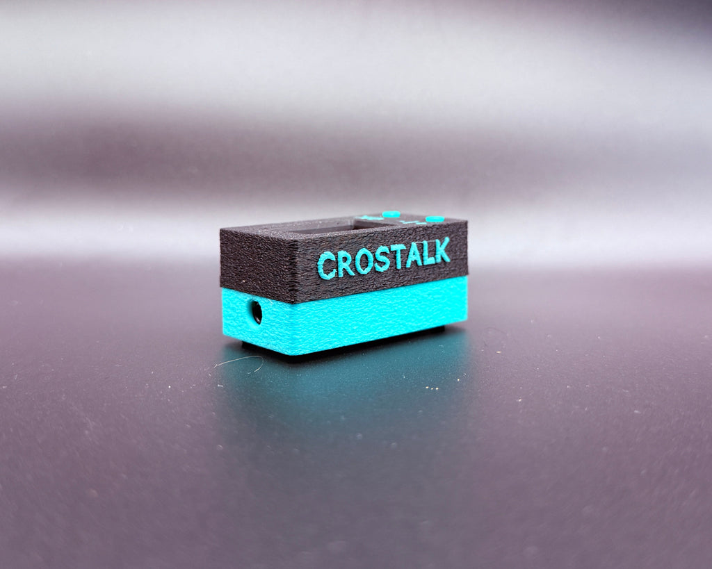 CROSTALK lying flat, showing the raised teal CROSTALK lettering and the 3.5mm headset jack